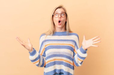 Genç sarışın kadın şok olmuş ve şaşırmış hissediyor.