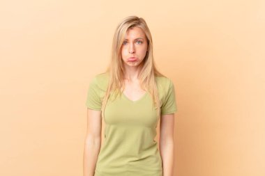 Genç sarışın kadın üzgün ve sızlanıyor. Mutsuz bir bakışla ve ağlamayla.