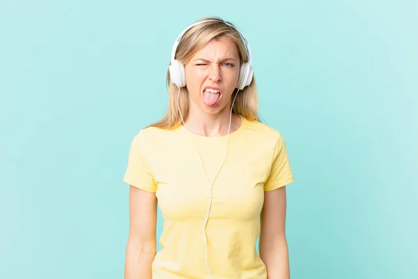 Młoda Blondynka Czuje Obrzydzenie Irytację Język Się Słuchanie Muzyki — Zdjęcie stockowe