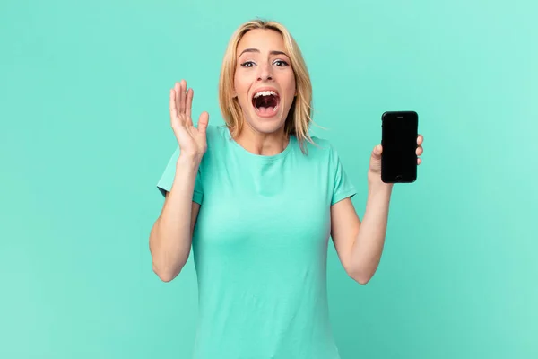 Młoda Blondynka Czuje Się Szczęśliwa Zdumiona Czymś Niewiarygodnym Trzyma Smartfon — Zdjęcie stockowe