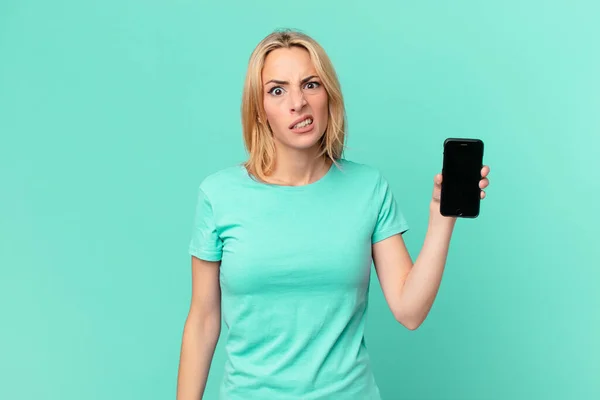 Młoda Blondynka Czuje Się Zakłopotany Zdezorientowany Trzyma Smartfon — Zdjęcie stockowe