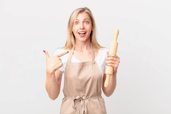 年轻的金发女人感到快乐 带着兴奋的心情指着自己 面包师概念 — 图库照片