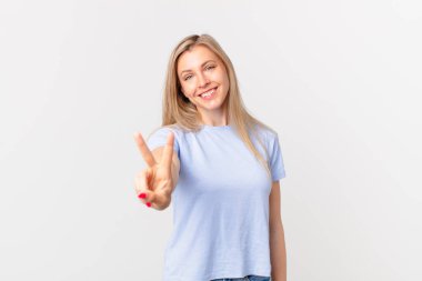 Genç sarışın kadın gülümsüyor ve arkadaş canlısı görünüyor.