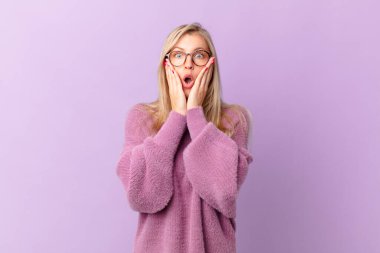 Genç sarışın kadın şok olmuş ve korkmuş hissediyor.