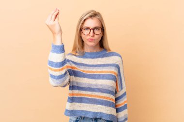 Genç sarışın kadın kapiş ya da para hareketi yapıyor, sana ödemeni söylüyor.