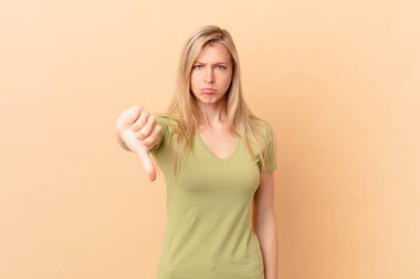 Genç sarışın kadın, kızgın hissediyor, baş parmağını kaldırıyor.