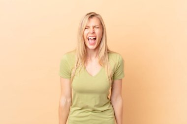 Genç sarışın kadın agresif bir şekilde bağırıyor, kızgın görünüyor.