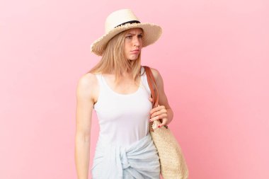 Genç sarışın kadın üzgün, üzgün ya da kızgın ve yana bakıyor. yaz konsepti