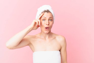 Genç sarışın kadın mutlu, şaşkın ve şaşırmış görünüyor.