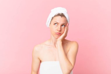 Genç sarışın kadın bıkkın, hayal kırıklığına uğramış ve uykulu hissediyor yorucu bir günün ardından ve duştan sonra