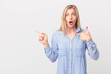 Genç sarışın kadın mutlu hissediyor ve heyecanla kendini işaret ediyor.