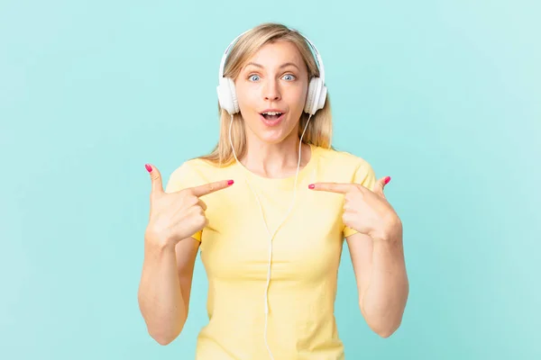 Young Blonde Woman Feeling Happy Pointing Self Excited Listening Music — Stockfoto