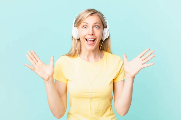 Young Blonde Woman Feeling Happy Astonished Something Unbelievable Listening Music — Stockfoto