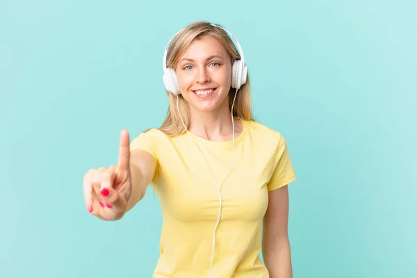 Young Blonde Woman Smiling Looking Friendly Showing Number One Listening — Fotografia de Stock