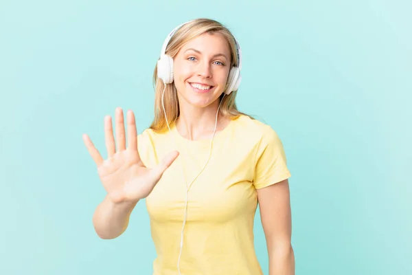 Young Blonde Woman Smiling Looking Friendly Showing Number Five Listening —  Fotos de Stock