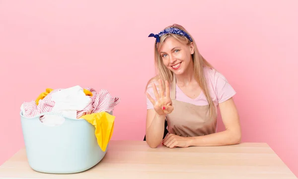 Giovane Donna Bionda Sorridente Amichevole Mostrando Numero Quattro Lavaggio Vestiti — Foto Stock