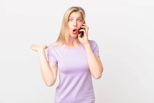 Young Blonde Woman Looking Surprised Shocked Jaw Dropped Holding Object — Stock Photo, Image