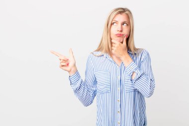 Genç sarışın kadın düşünüyor, kuşkulu ve şaşkın hissediyor.