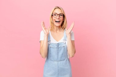 Genç sarışın kadın kendini mutlu hissediyor ve inanılmaz bir şeye hayret ediyor.