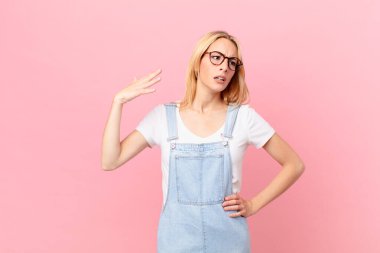 Genç sarışın kadın stresli, endişeli, yorgun ve hayal kırıklığına uğramış.