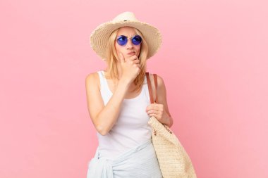 Genç sarışın kadın düşünüyor, kuşkulu ve şaşkın hissediyor. yaz konsepti