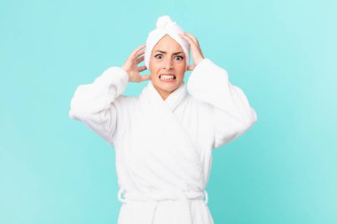 Genç sarışın kadın stresli, endişeli ya da korkmuş hissediyor, elleri başının üstünde. duş kavramı.