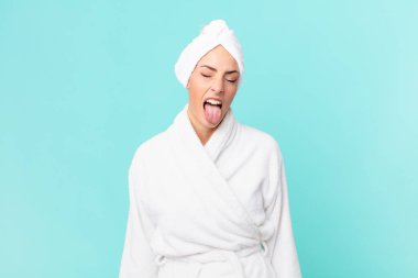 Genç, sarışın, neşeli ve asi tavırlı, şaka yapan ve dilini dışarı çıkaran bir kadın. duş kavramı.