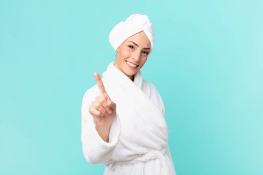 Genç sarışın kadın gururla gülümsüyor ve kendinden emin bir numara oluyor. duş kavramı.