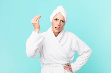 Genç sarışın kadın kapiş ya da para hareketi yapıyor, sana ödemeni söylüyor. duş kavramı.