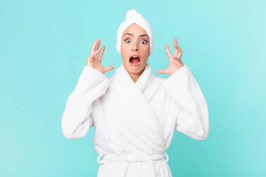 Genç sarışın kadın ellerini havaya kaldırarak çığlık atıyor. duş kavramı.