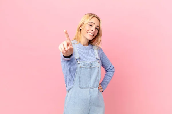 Young Blonde Woman Smiling Proudly Confidently Making Number One — Stock Photo, Image