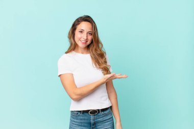 Güzel bir kadın neşeyle gülümser, mutlu hisseder ve bir konsept gösterir.