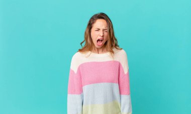 Güzel kadın agresif bir şekilde bağırıyor, çok kızgın görünüyor.