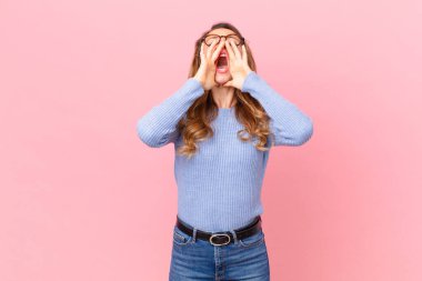 Güzel bir kadın kendini mutlu hisseder. Elleri ağzında bağırır.