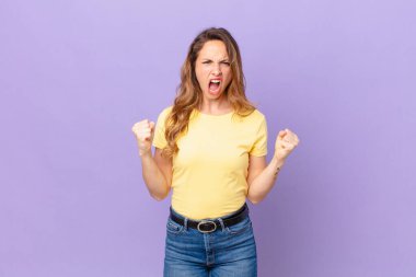 Güzel bir kadın sinirli bir ifadeyle agresif bir şekilde bağırıyor.