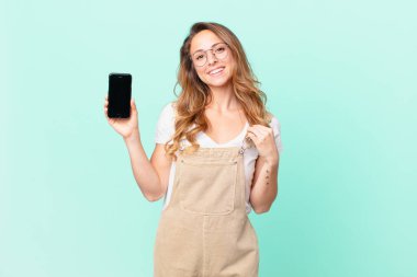 Güzel bir kadın kibirli, başarılı, pozitif ve gururlu görünüyor ve elinde bir akıllı telefon tutuyor.