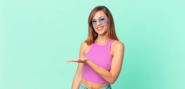 Güzel, yetişkin bir kadın neşeyle gülümsüyor, mutlu hissediyor ve bir konsept gösteriyor.