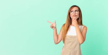 Düşünen, kuşkulu ve kafası karışık güzel bir kadın ve bir kopya alanı.