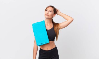 Güzel kadın şaşkın ve kafası karışık, kaşınan bir kafa hissediyor. fitness konsepti