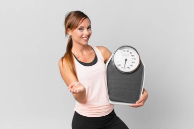 Güzel bir kadın mutlu bir şekilde gülümsüyor ve bir konsept sunuyor. diyet kavramı