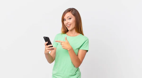 Mulher Bonita Olhando Animado Surpreso Apontando Para Lado Usando Smartphone — Fotografia de Stock