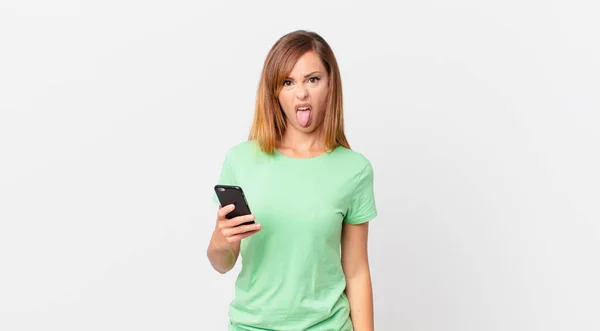 Jolie Femme Sentant Dégoûté Irrité Langue Dehors Utilisant Smartphone — Photo