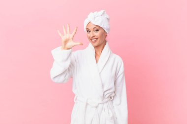 Güzel bayan gülümsüyor ve arkadaş canlısı görünüyor, beş numarayı gösteriyor. spa konsepti