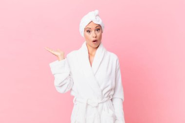 Güzel kadın şaşırmış ve şok olmuş görünüyor. Çenesi düşmüş ve elinde bir nesne tutuyor. spa konsepti