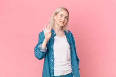 Sarışın, güzel bir kadın gülümsüyor ve arkadaş canlısı görünüyor.