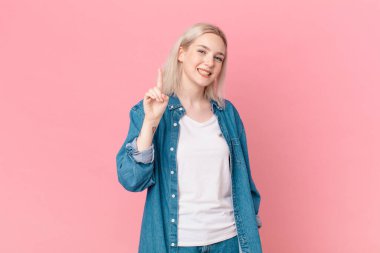 Sarışın, güzel bir kadın gülümsüyor ve arkadaş canlısı görünüyor.