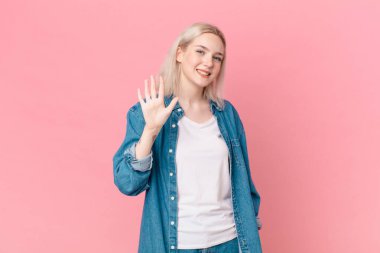 Sarışın, güzel bir kadın gülümsüyor ve arkadaş canlısı görünüyor.