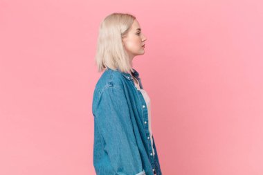 Profilde sarışın güzel bir kadın. Düşünüyor, hayal ediyor ya da hayal kuruyor.