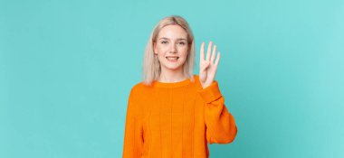 Sarışın, güzel bir kadın gülümsüyor ve arkadaş canlısı görünüyor.