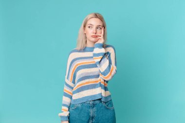 Sarışın, güzel bir kadın. Sıkılmış, hayal kırıklığına uğramış ve uykulu.